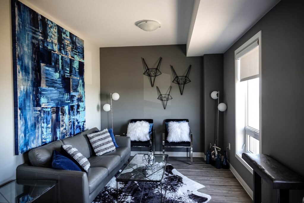 A large, blue abstract painting on a living room wall behind a sofa