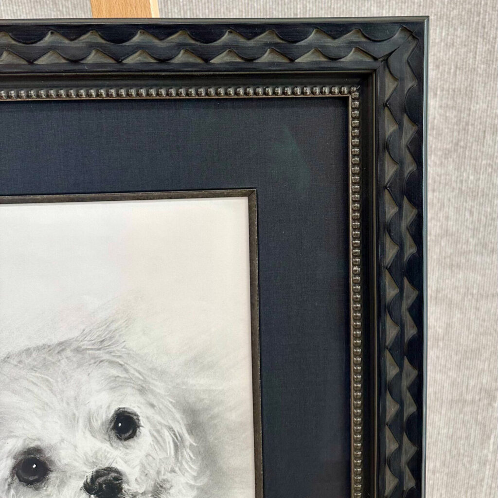 A closeup of a picture frame with dark blue matting