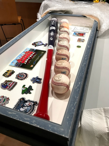 Framed shadow box display with baseball memorabilia.