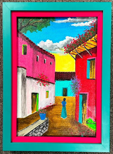 Colorfully framed and matted painting of vibrantly colored buildings.