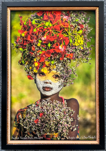 Photograph of a young girl with traditional face paint and headdress.