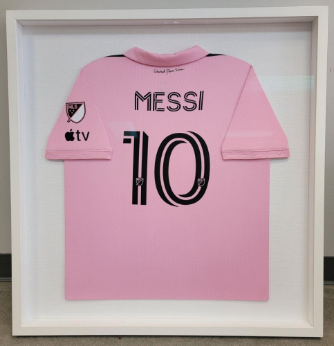 Messi sports jersey mounted and showcased in a light shadow box frame.